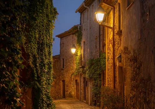 Nighttime view of an alleyway along stone buildings