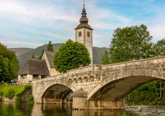 Large stone bridge with a bell tower in the background