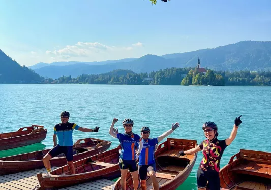 Group of people standing on wooden boats by a large lake