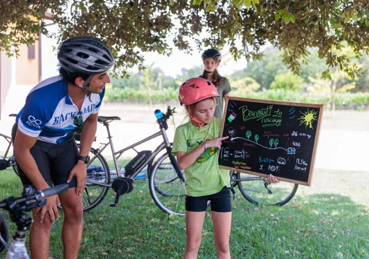 Girl pointing at a chalkboard with a man kneeling down and smiling