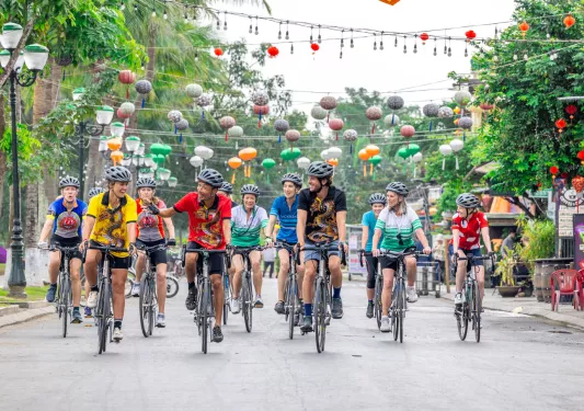 Group of bikers riding on an empty, with a small town in the background