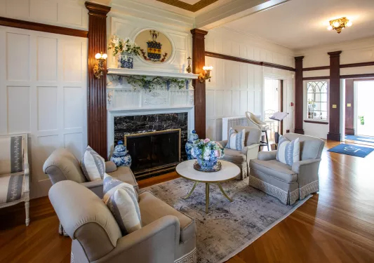 Hotel lobby with cushioned chairs in front of a fireplace
