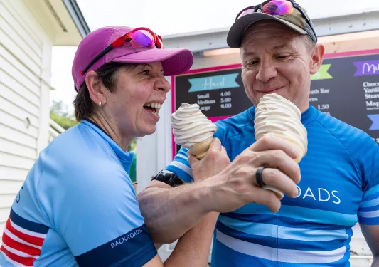 Man and woman interlocking arms and eating soft-serve ice cream