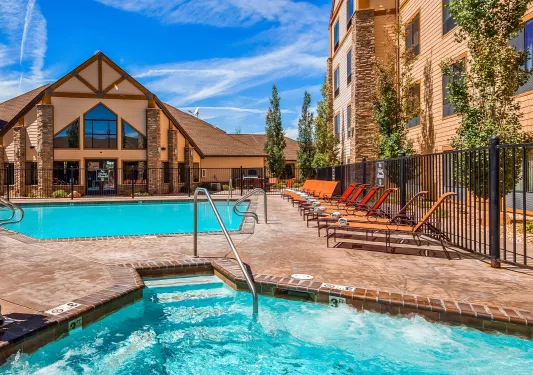 Outdoor pool of a hotel, surrounded by brown hotel buildings