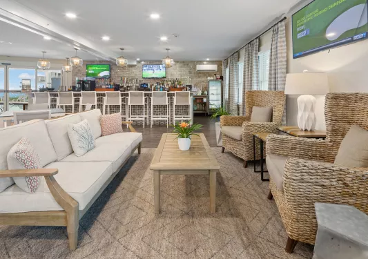 Bar and lounge with cushioned chairs with a bar counter in the back