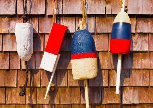 Four buoys hanging on a wooden wall