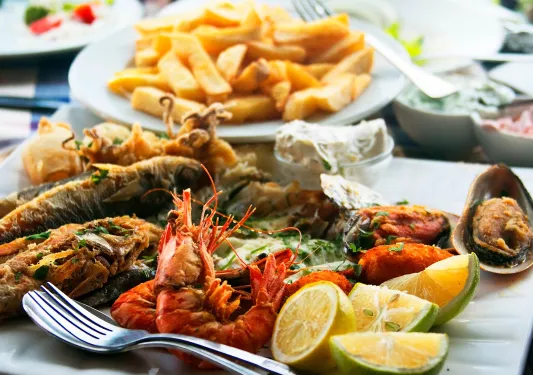 Plate of boiled seafood and a plate of french fries
