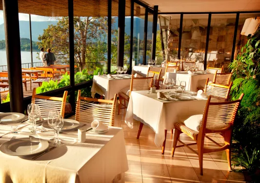 Dining area with large windows and the sunshine hitting each dining table