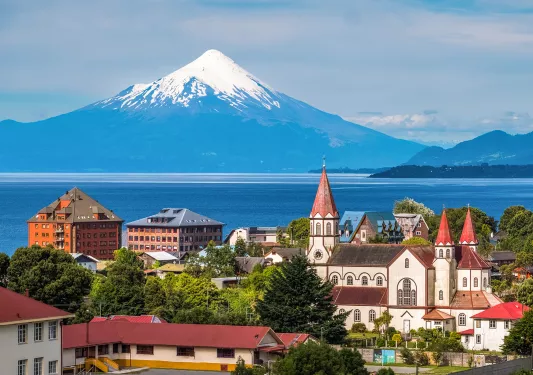 Small town with a lake and snow-capped mountain in the distance