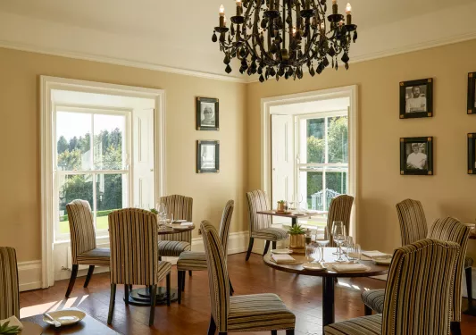 Restaurant dining area with circular tables and striped, beige chairs