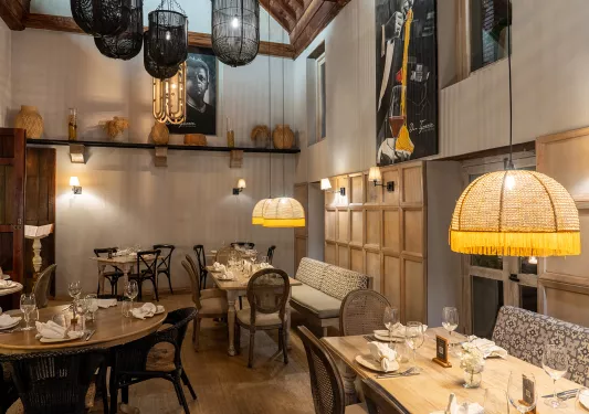 Indoor dining area with gold and black light fixtures and paintings on the walls