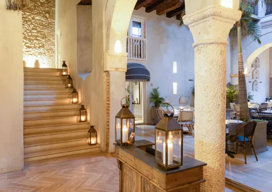 Indoor lounge with candles along a staircase to the left