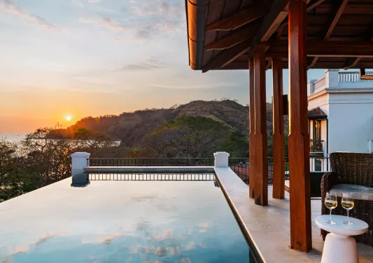 Outdoor pool with mountains and the ocean in the distance