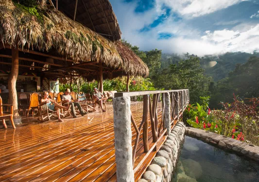 Outdoor patio with wooden and stone fencing, with mountains in the distance