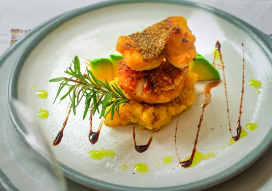 Plate of food with fried fish and garnishes