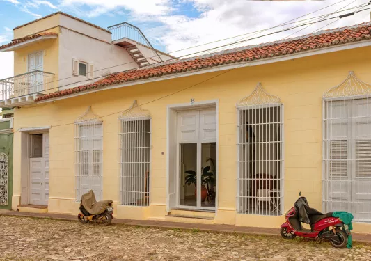 Exterior view of yellow building with two motor scooters outside