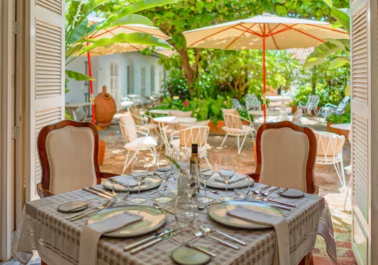 Outdoor dining area with silverware and wine glasses on the tables