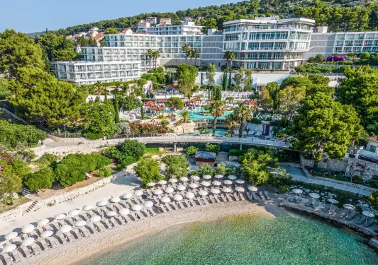 Exterior view of hotel complex with an outdoor pool and the beach on the ground level
