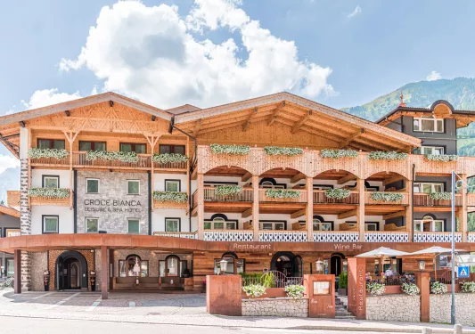 Exterior view of multi-story hotel building with mountains in the distance