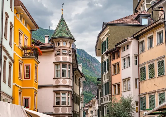 Alleyway of large houses and apartments with mountains in the distance