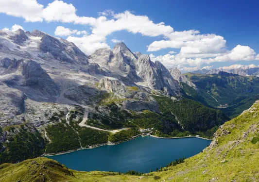 Lake surrounded by grassy hills and tall mountains