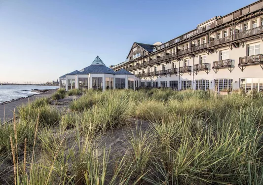 Long hotel building with outdoor balconies and the ocean to the left