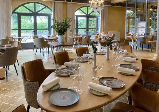 Dining area with large, oval-shaped tables and cushioned chairs