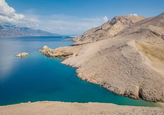 Large, cried mountains, with the ocean to the left