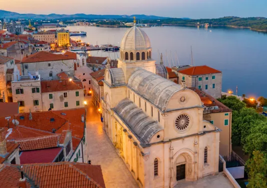 Sky view of rustic town with a church and bell tower by the ocean