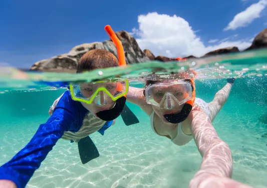 Boy and girl shallow snorkeling in the ocean