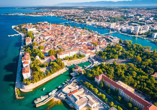 Sky view of a town with white and orange buildings, surrounded by water