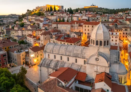 Rustic town with beige and brown buildings and a bell tower in the center