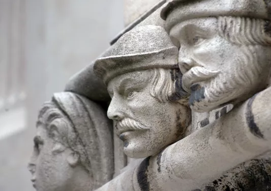 Statue of three men with black specks