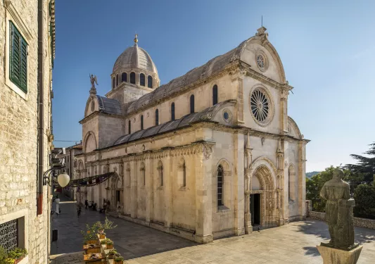 Rustic, stone church building with statues in front