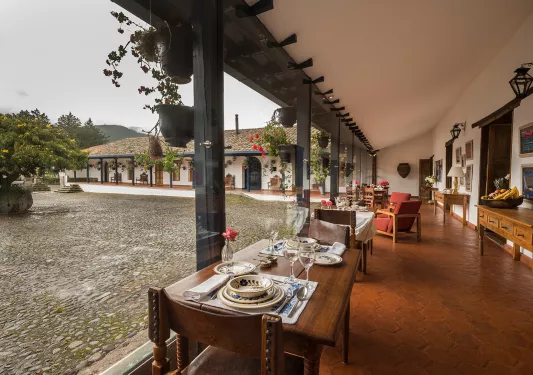 Outdoor courtyard with dining tables to the right by a building