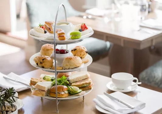 Three-tier plate full of pastries and sandwiches