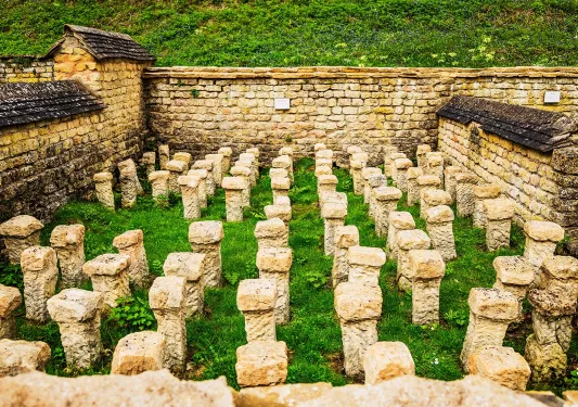 Brick walled area with stone pillars in grass