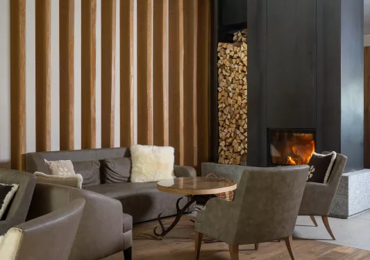 Lounge area with gray, leather couches with a fireplace to the right