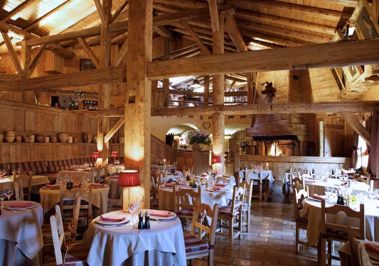 Indoor dining hall of a wooden lodge with giant wooden pillars