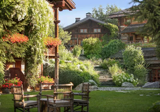 Outdoor garden and grass area with a wooden lodge in the background