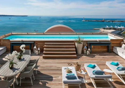 Outdoor patio with a pool looking out to the ocean