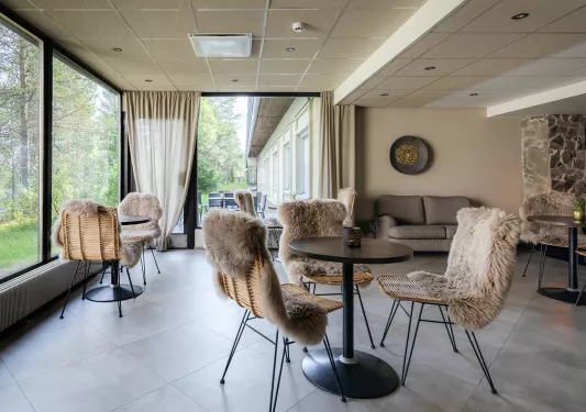 Lobby and seating area with woven chairs covered with fur cushions