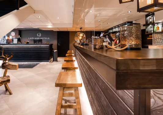 Bar counter with wooden stools, and a black counter in the background