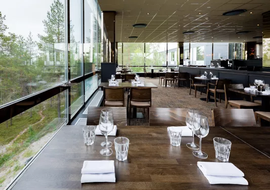 Dining area with wine glasses and handkerchiefs on each table