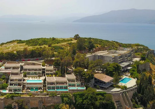 Exterior, sky view of a large hotel complex on top of a hill, with mini outdoor pools