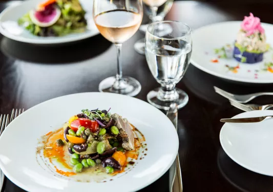 Plates full of salad and wine glasses to the right
