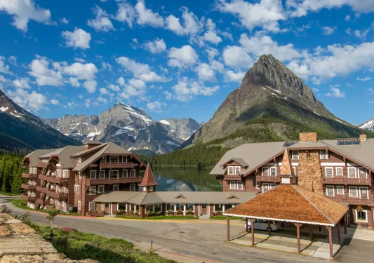 Exterior view of wooden cabin buildings in front of large lakes and mountains