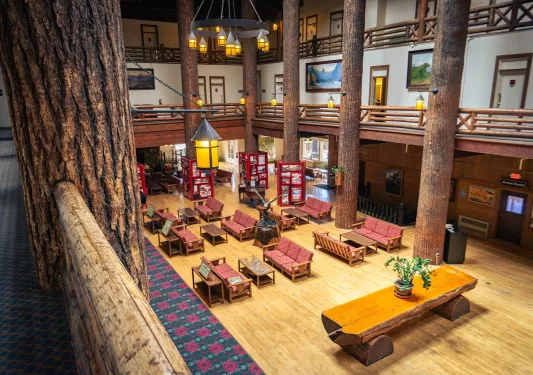 Hotel lodge lobby with cushioned seats and large, wooden pillars