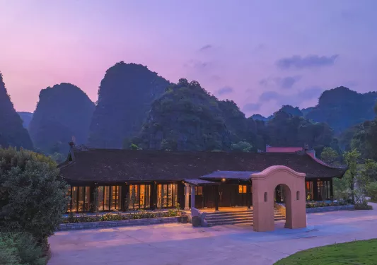 Exterior view of building with sunset and large mountains in the background