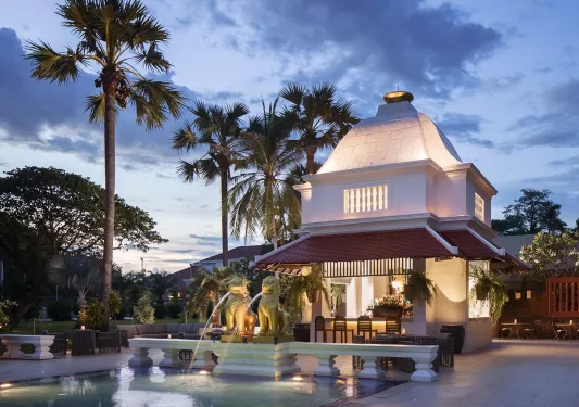Exterior view of illuminated building with a fountain in front